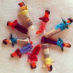 A circle of small cloth Worry Dolls. in bright colors. 