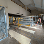 Photo from inside the new uCreate space. The walls are framed in metal studs and there is a rack of construction pieces and a ladder in the space. 